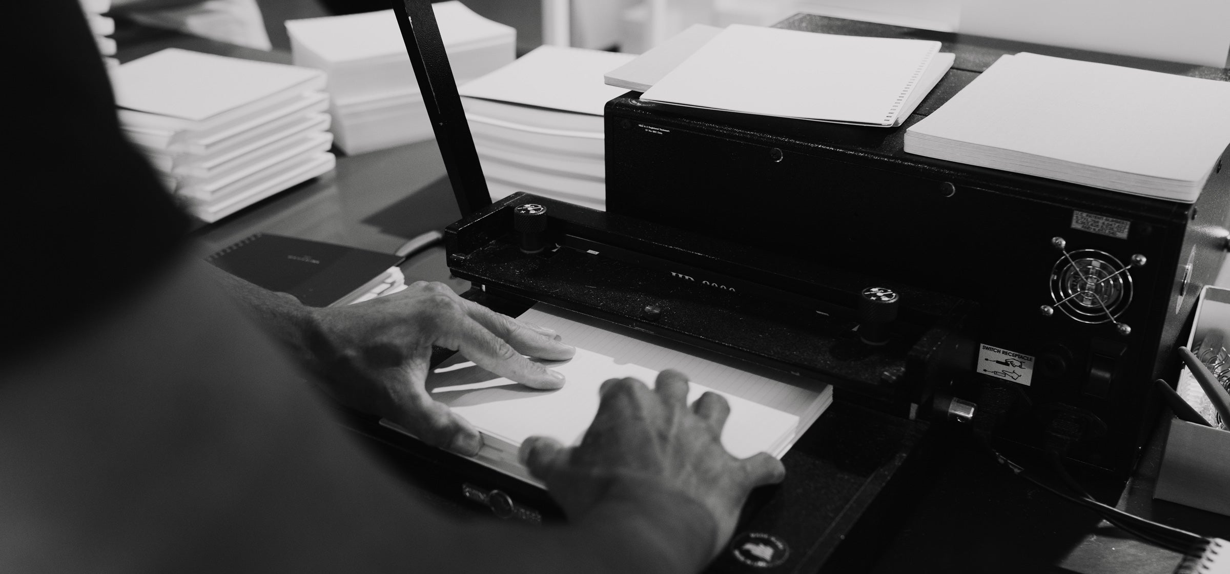 Jaime uses the collator machine at the Appointed Studio, collating stacks of Year Task Planners