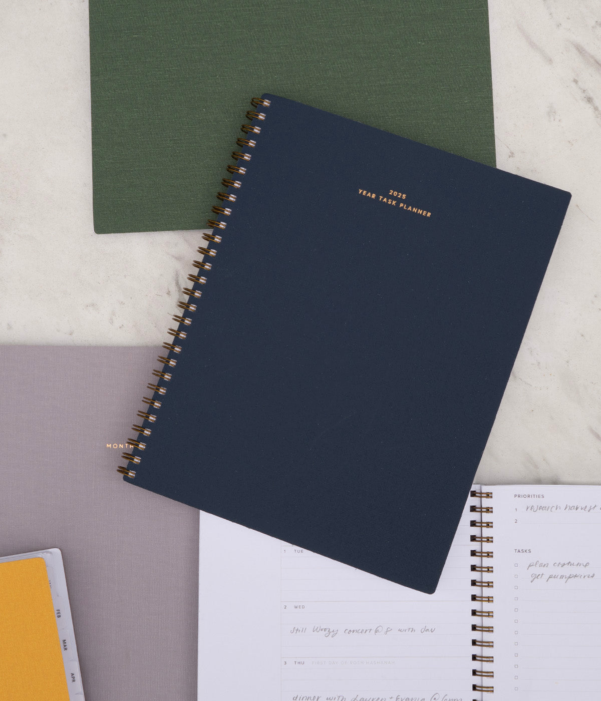 2025 Planners are stacked against a table